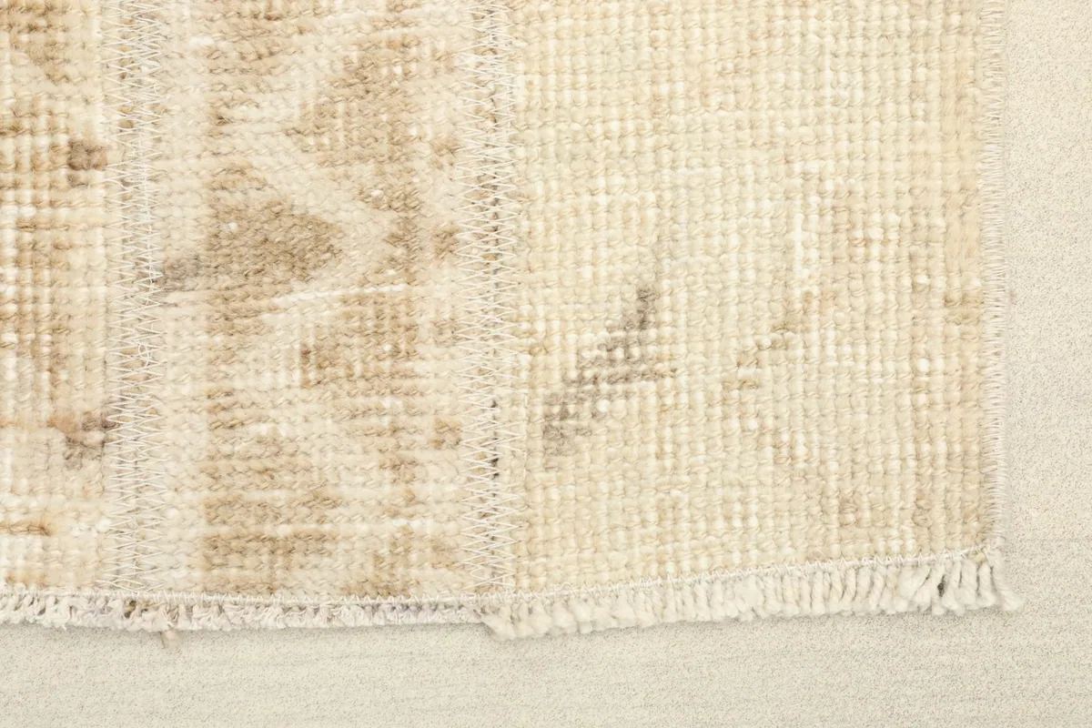 Close-up detail of the hand-knotted wool pile and cotton foundation, showing texture and wear.