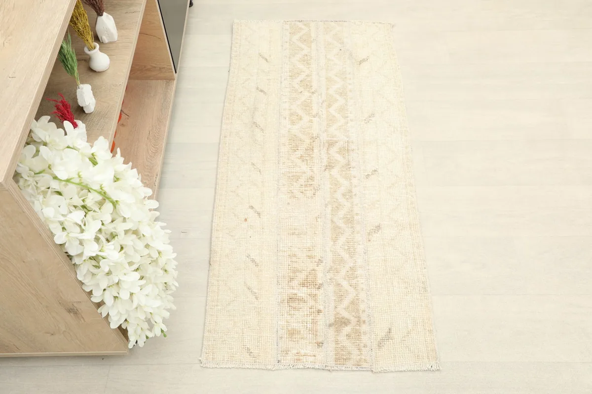 Overhead view showcasing the full length and subtle geometric patterns of the tan vintage rug.