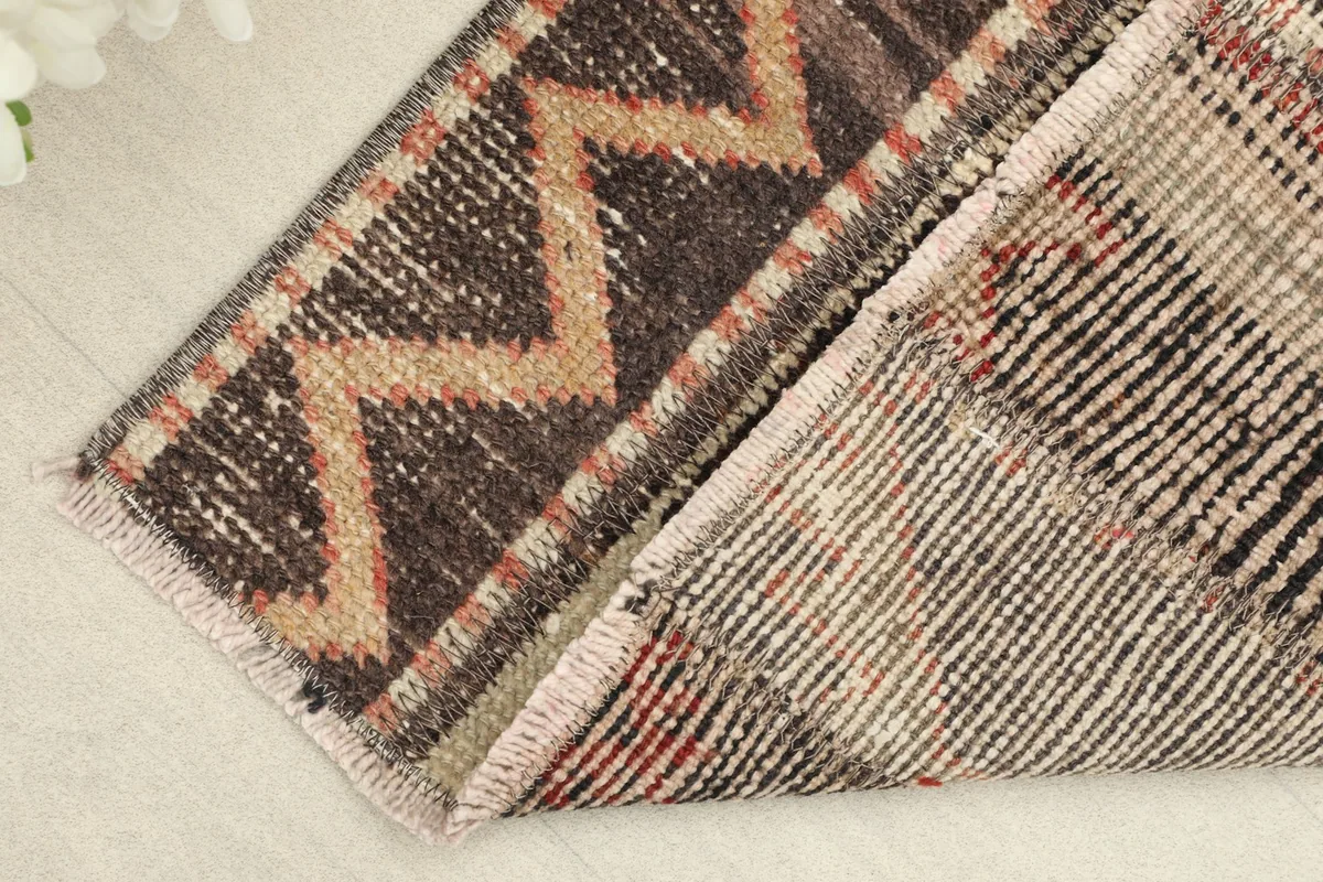 View of the rug's back and folded edge, revealing the cotton foundation