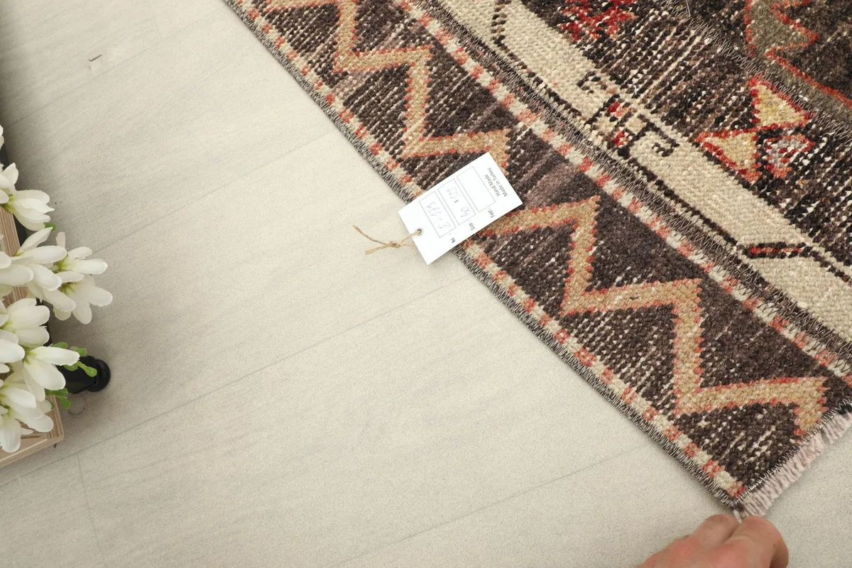 Corner of the rug with a tag, showing the overall texture and colors