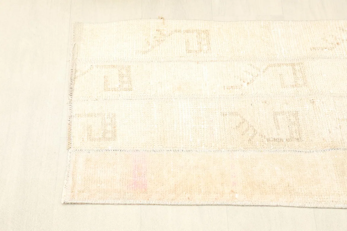 View of one end of the rug, showing the low pile and the patchwork seams.