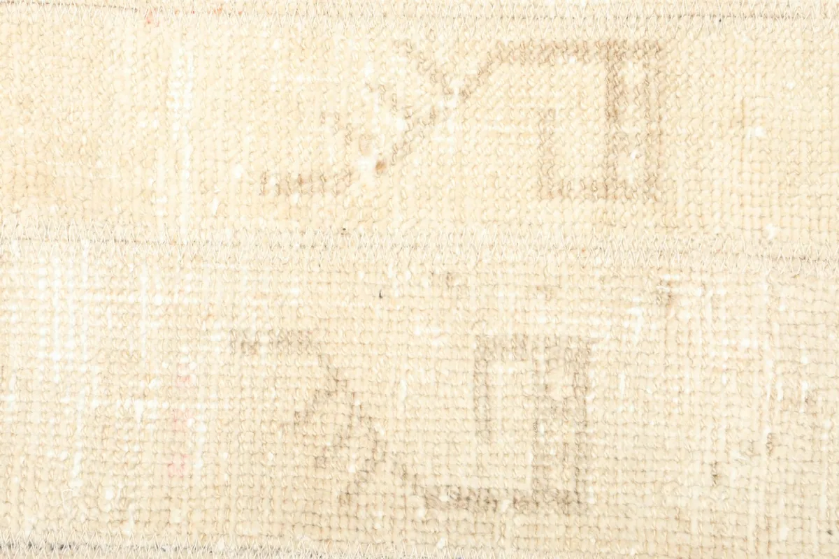 Detailed shot of the hand-knotted wool pile and the intricate, worn geometric patterns.