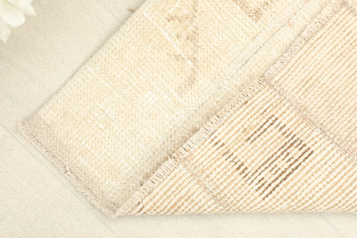 Corner folded to show the cotton foundation and the reverse side of the hand-knotted construction.