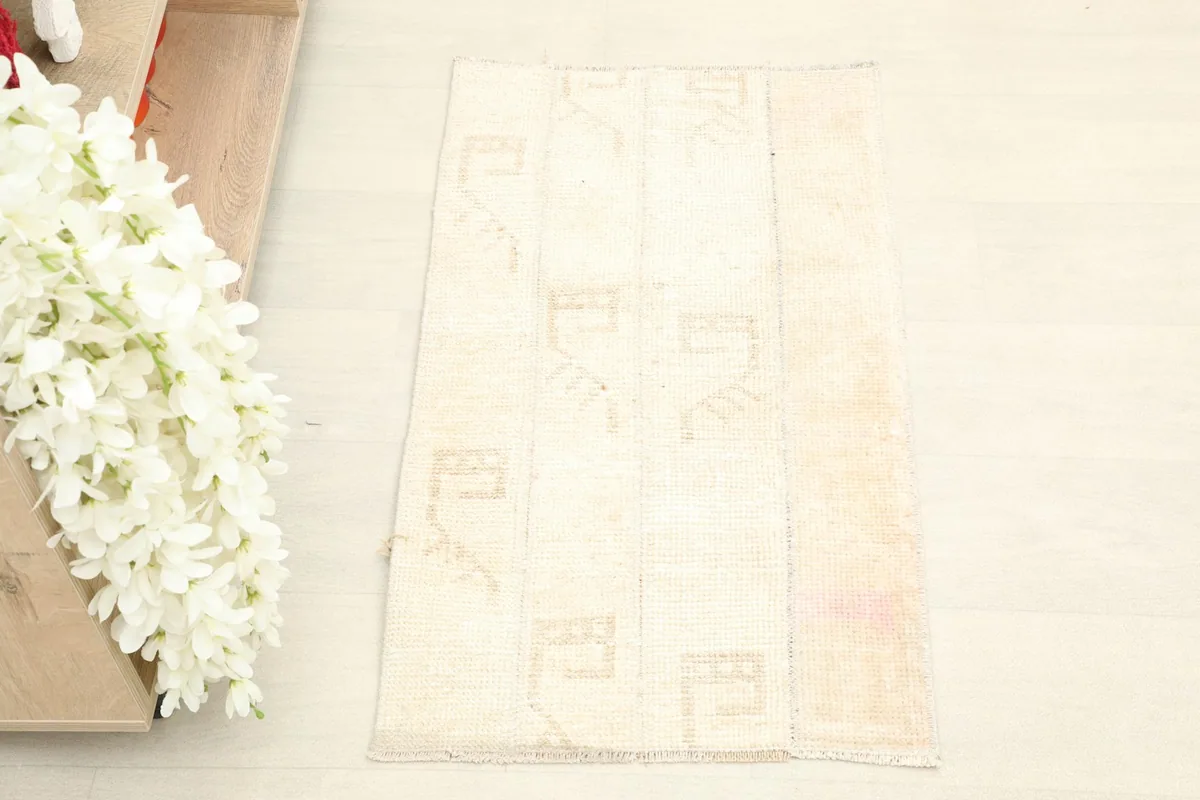 Overhead view of the ivory and beige patchwork rug, showing its rectangular shape and geometric patterns.