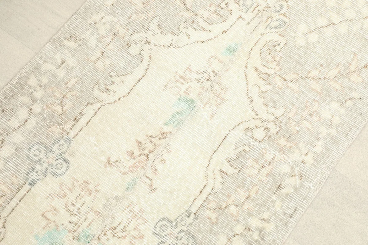 Angled view highlighting the central ivory field and subtle floral pattern.