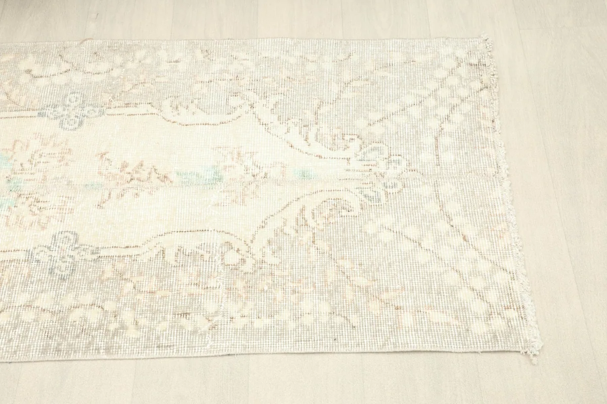 Corner view of the rug, illustrating the distressed look and color variations.
