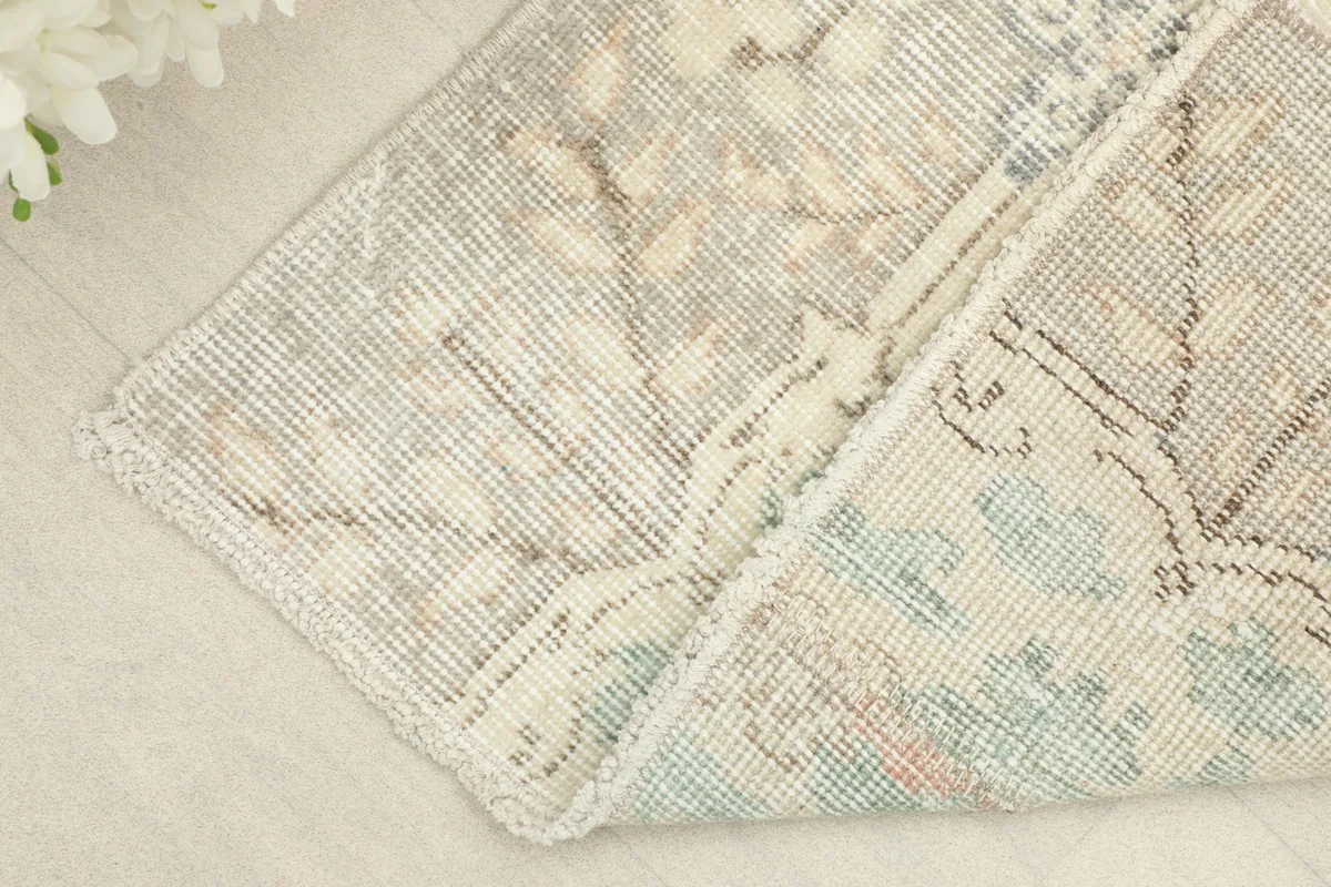 View of the rug folded to show the back of the hand-knotted wool pile on cotton foundation.