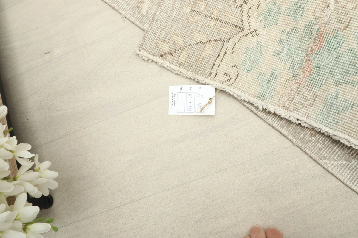 Top-down view showing the rug with a size tag for scale and reference.