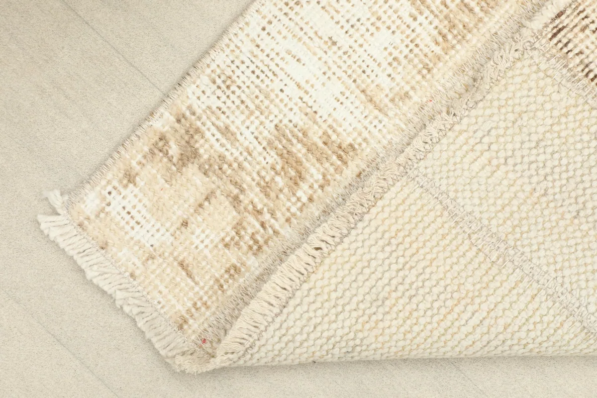 View of the back of the hand-knotted wool rug, showing the cotton foundation and construction.