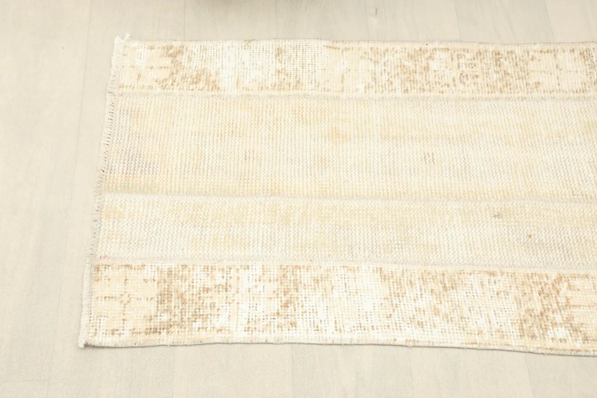 Overhead shot of one end of the runner rug, showing the distressed border and central field.