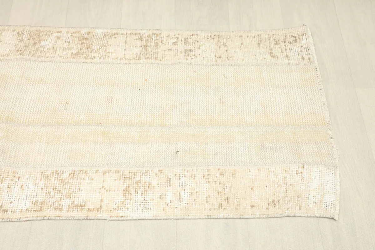 Overhead shot of the other end of the runner rug, displaying the muted tan patterns.
