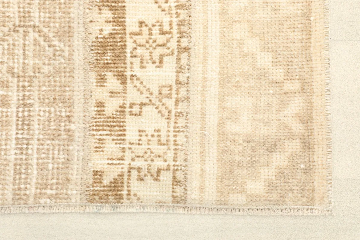 Close-up view of the tribal and geometric patterns within the stripes of the vintage rug.
