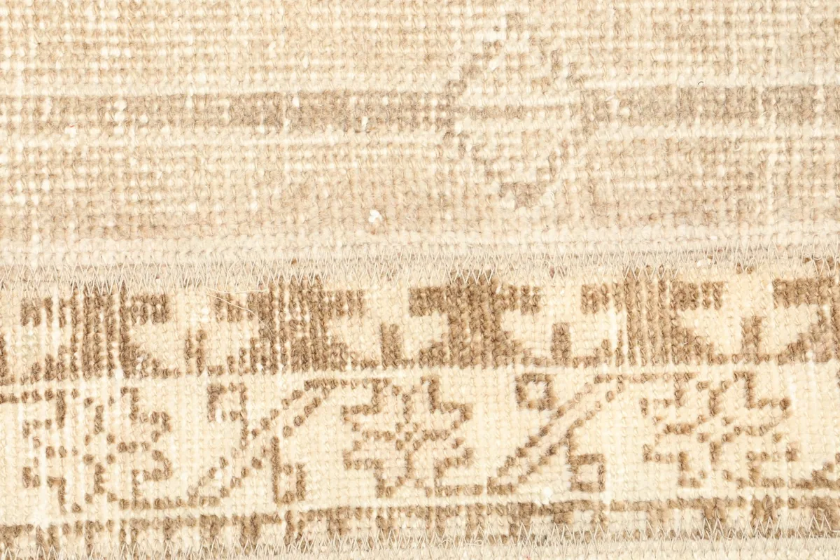 Detailed view of the hand-knotted wool pile and intricate tribal designs in the rug's central stripe.