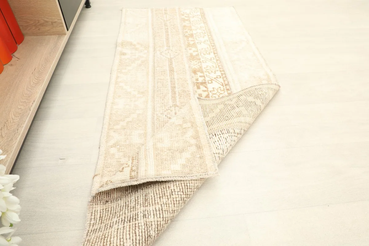 The rug partially folded, showcasing the back of the rug and the density of the knots.