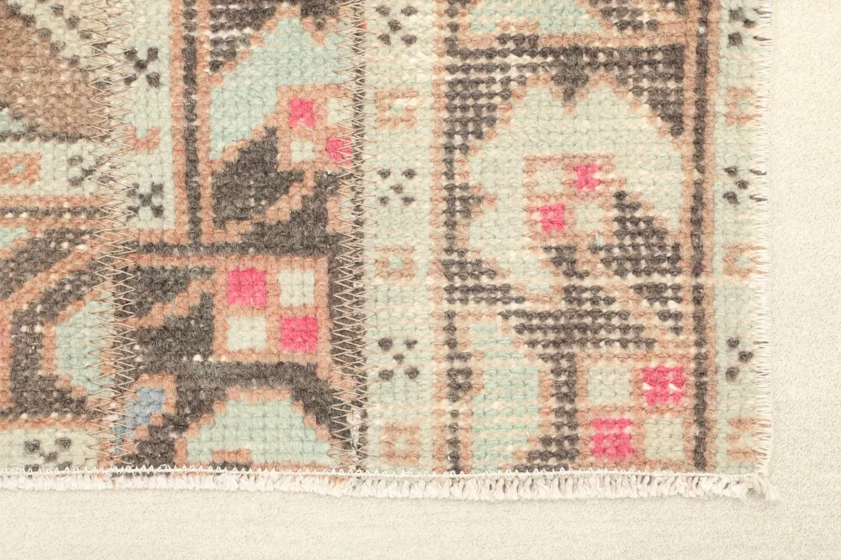 Close-up detail of the rug's corner, showing the intricate tribal geometric patterns and colors.