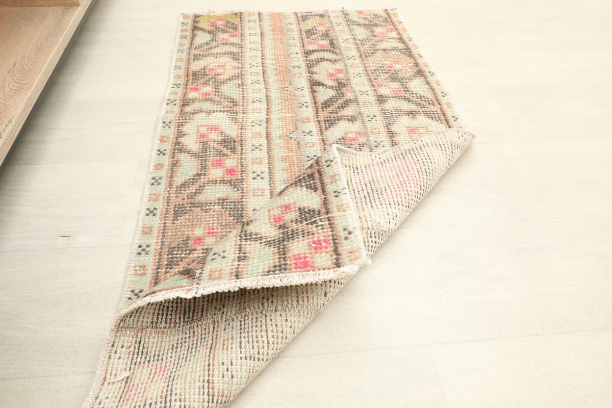 View of the rug partially folded to show the cotton foundation and the reverse side.