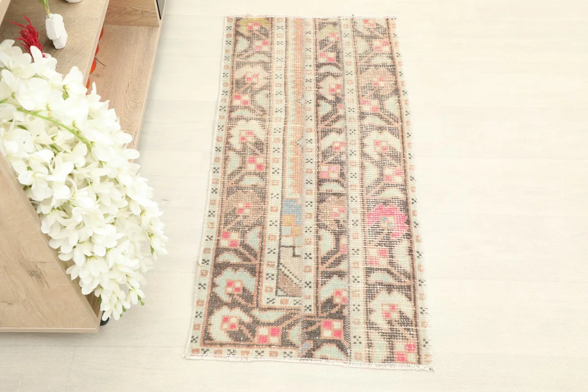 Overhead view showcasing the cream field with brown and pink tribal patterns of the rug.