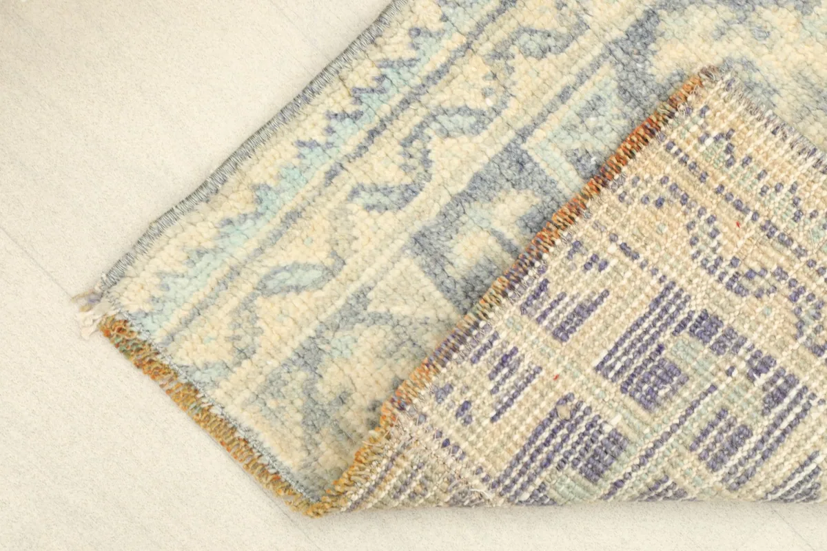 Corner folded to show the hand-knotted cotton foundation and wool pile