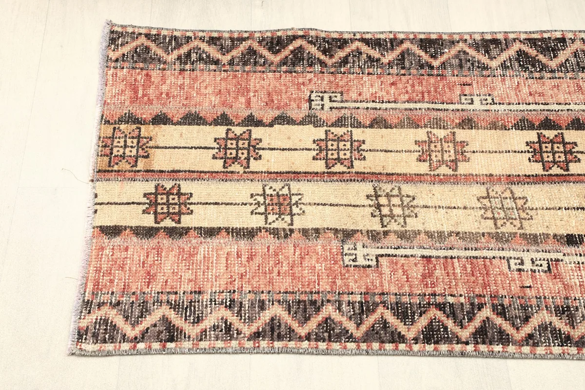 View of one end of the rug, showing the consistent striped and geometric design.