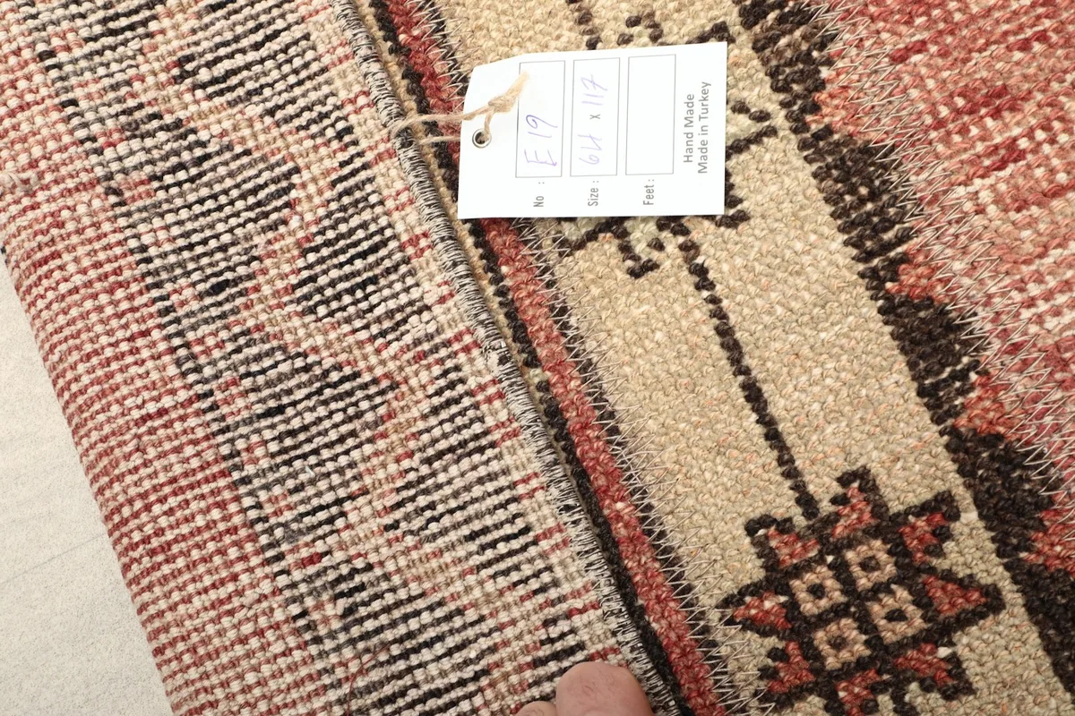 Close-up of the rug's pile and the back with a product tag, indicating its origin and material.