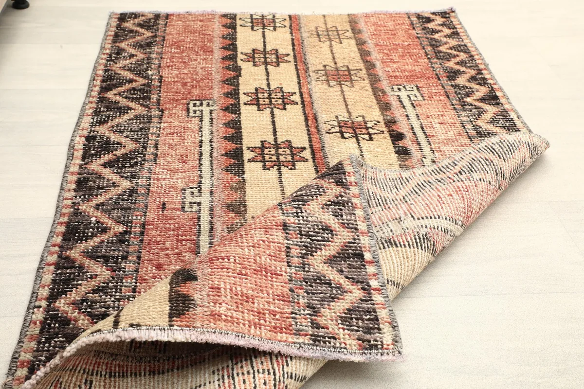 Rug folded to show its flexibility and the thickness of the hand-knotted wool pile.