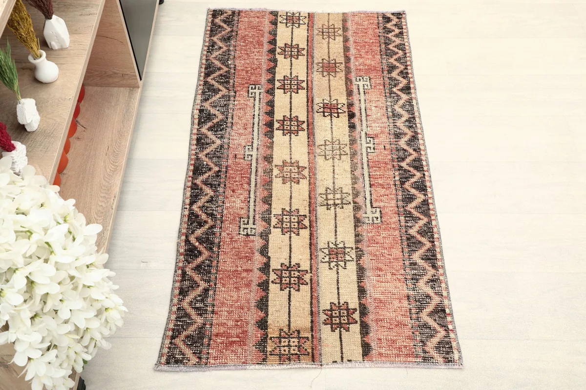 Direct overhead shot of the hand-knotted wool rug, showcasing its rust, beige, and black design.