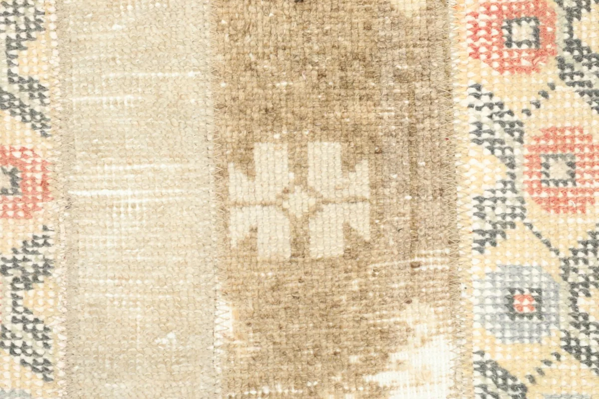 Detailed shot of a brown patch with a faded white floral motif, showing the low pile texture.