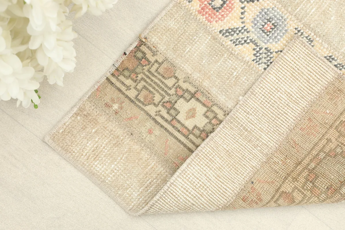 Corner of the rug folded to reveal the cotton foundation and hand-knotted construction.