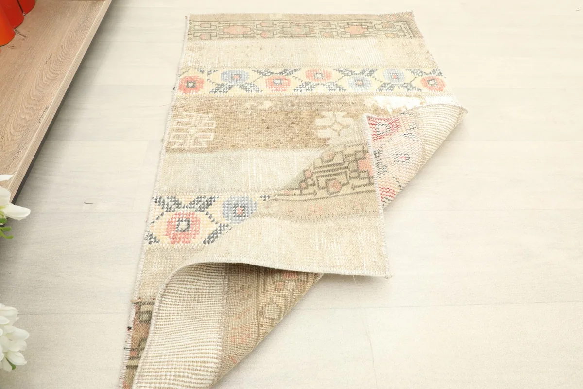 Rug partially folded, displaying the back of the rug and the varied patterns on the front.