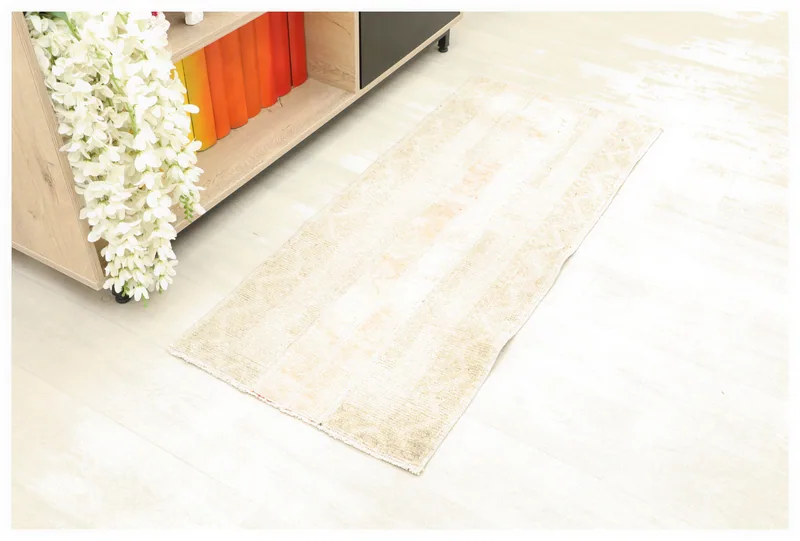 Full top view of the 1'9" x 4'0" beige and rose vintage Anatolian rug on a white background.