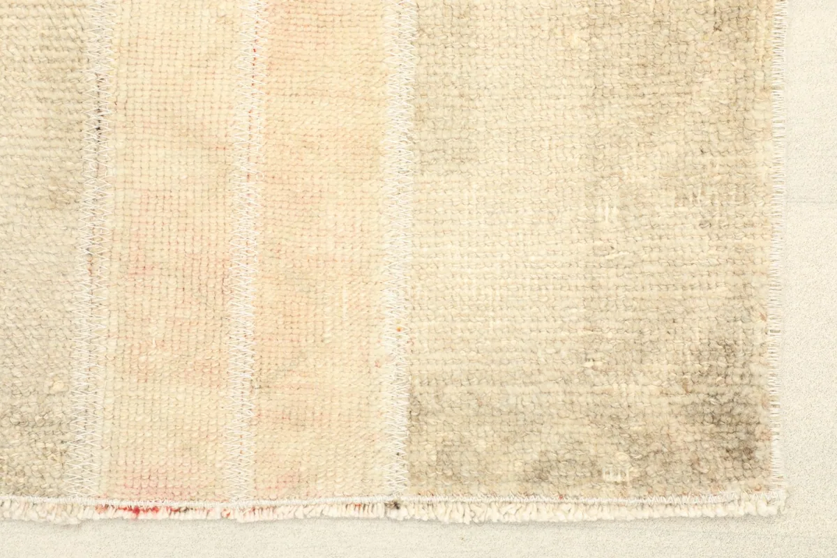 Close-up detail of the rug's end, showing the low pile and intricate weave.