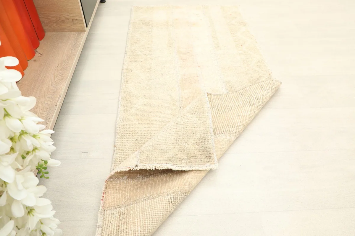 Another view of the rug's corner folded, showing the reverse side and texture.