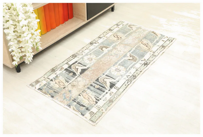 Full top view of the vintage beige and blue patchwork rug on a white background.