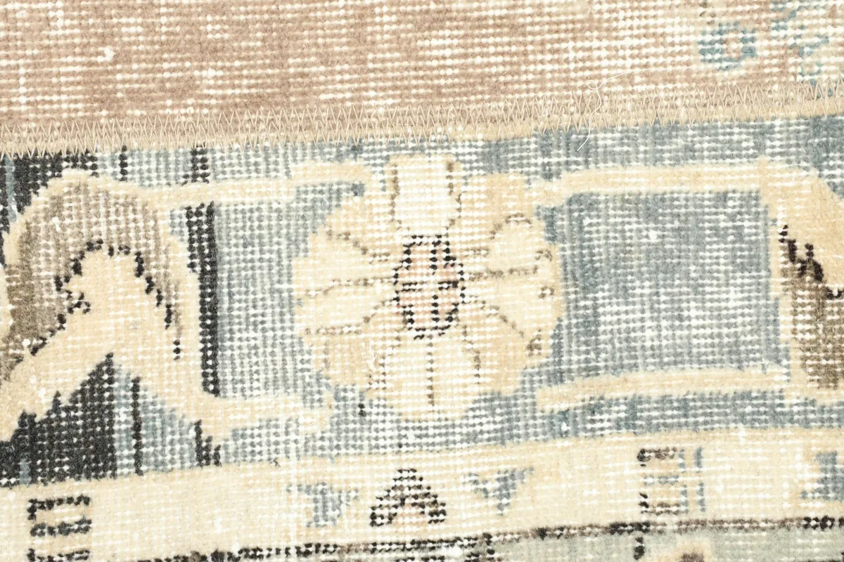 Detailed view of a specific motif within one of the rug's patchwork panels, showing wear.
