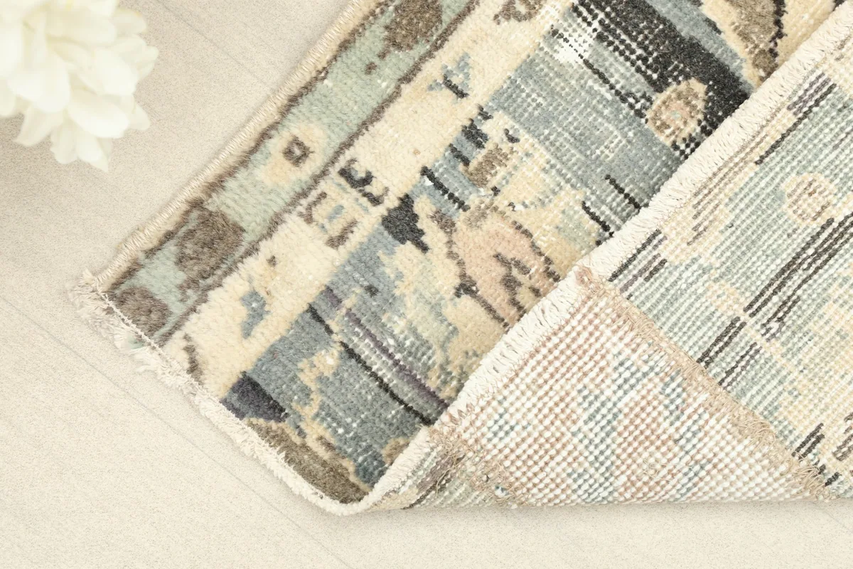 Corner view revealing the cotton foundation and the reverse side of the hand-knotted rug.