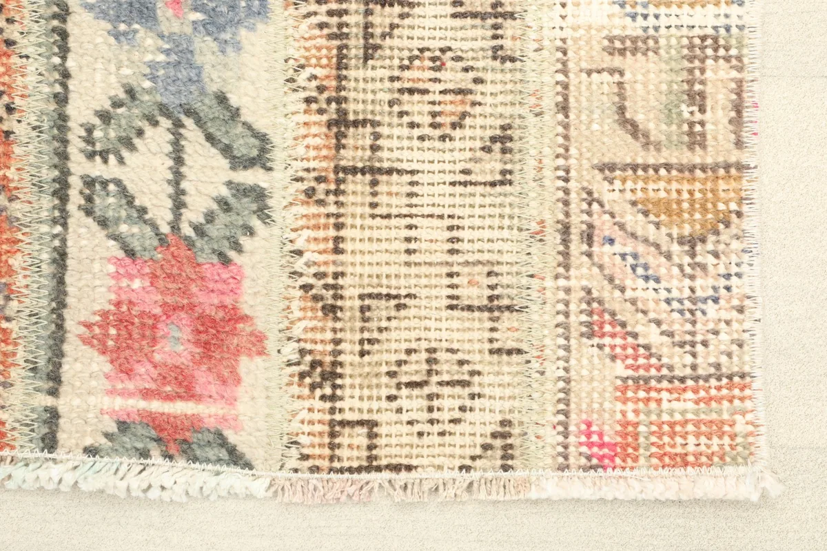 Close-up detail of one end of the runner, highlighting the rose floral and geometric patterns.