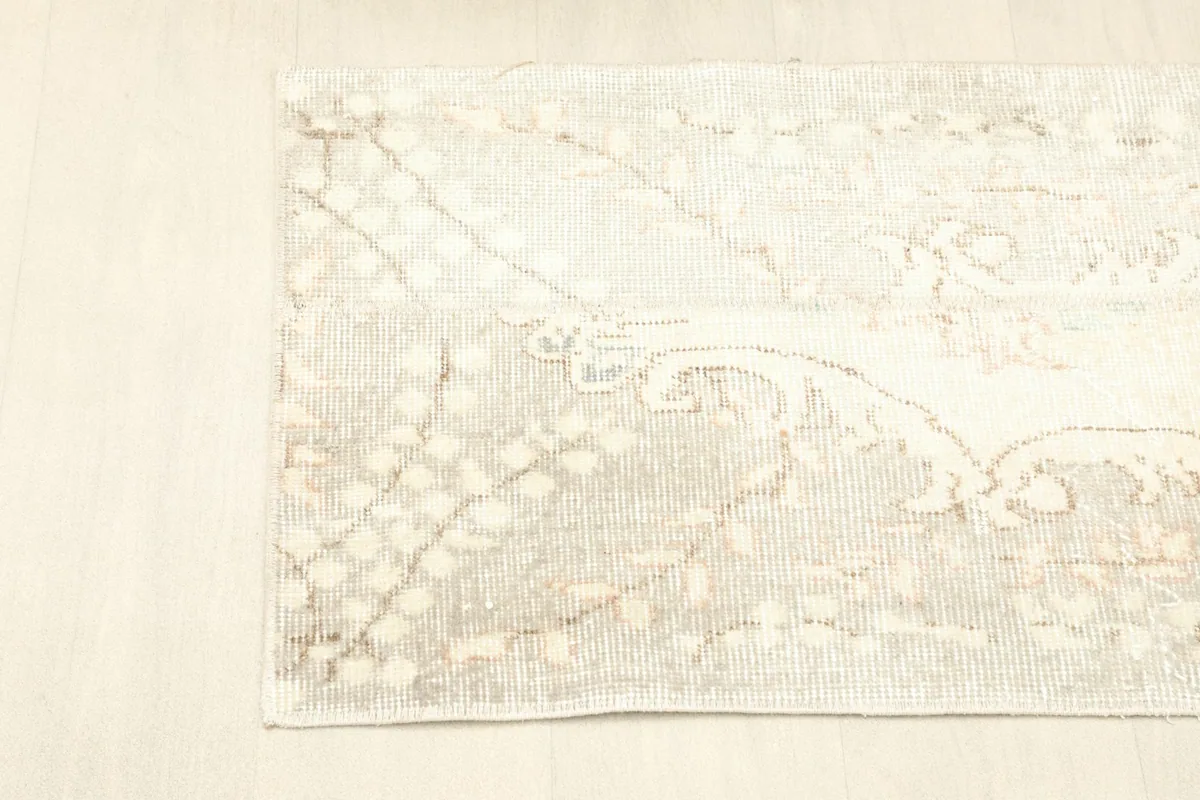 View of the rug from an upper angle, displaying the overall beige and ivory color palette.