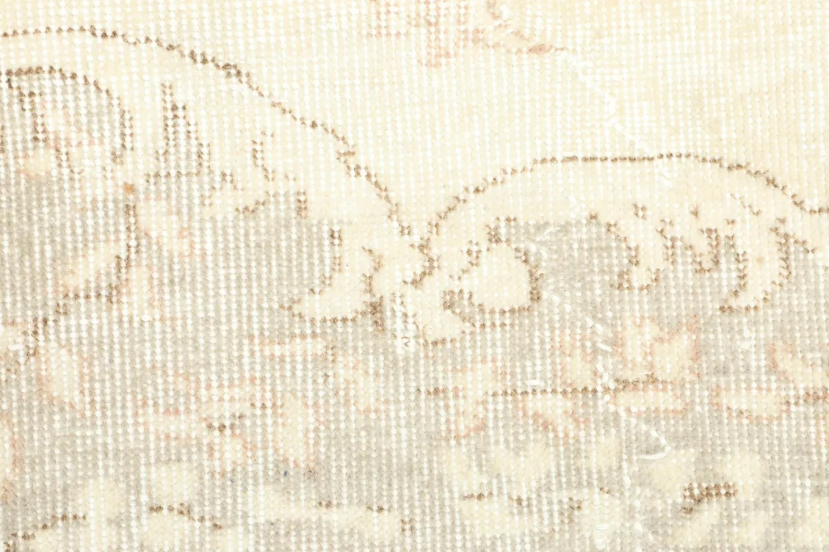 Detailed shot of the wool pile, revealing the hand-knotted texture and faded tan patterns.