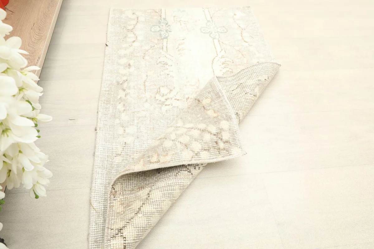 Rug partially folded, illustrating its flexibility and the hand-knotted construction.