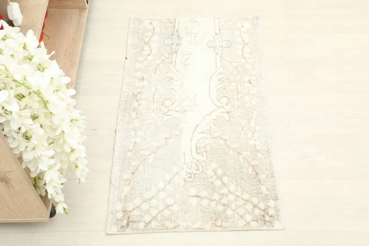Top-down view of the mini beige rug, highlighting its full pattern and soft colors.