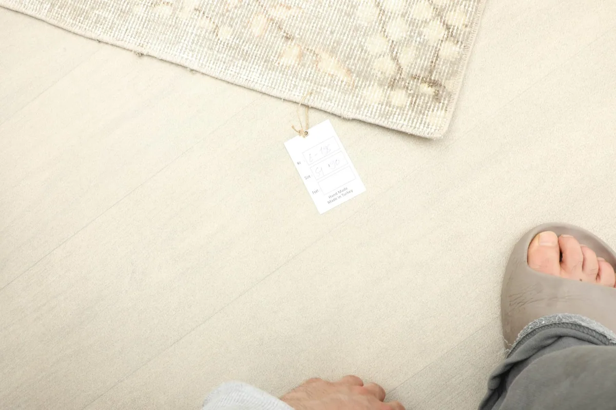 Overhead view with a foot next to the rug, indicating its mini size and scale.