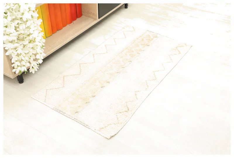 Full top view of the beige and tan striped geometric vintage Anatolian rug on a white background.