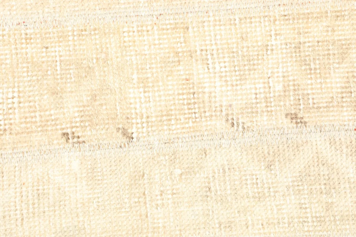 Detailed view of the hand-knotted wool pile and cotton foundation, showing vintage wear.