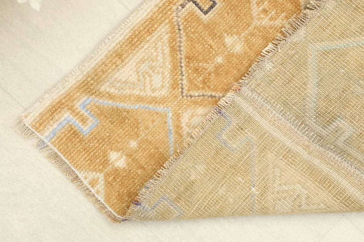 Corner of the rug folded to reveal the wool pile and cotton foundation