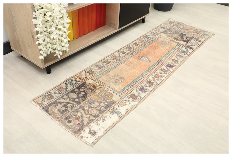 Full top view of the 1'9" x 6'0" orange and navy vintage Anatolian runner rug on a white background.