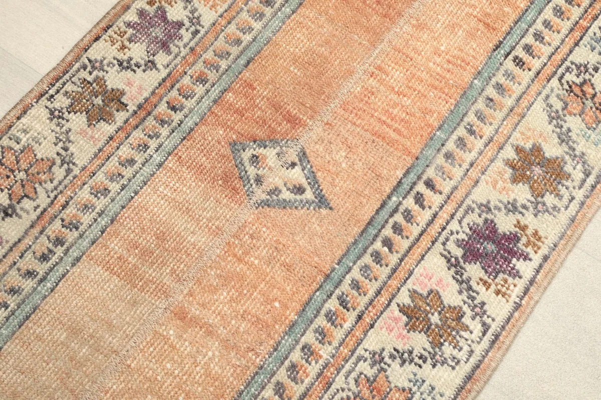 Angled close-up of the orange central field with a geometric motif and border details.