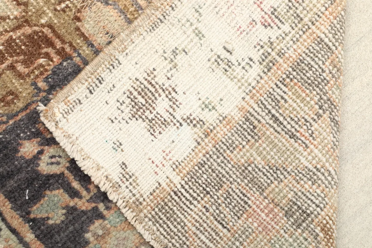 View of the back of the hand-knotted wool rug, showing the cotton foundation and knotting.