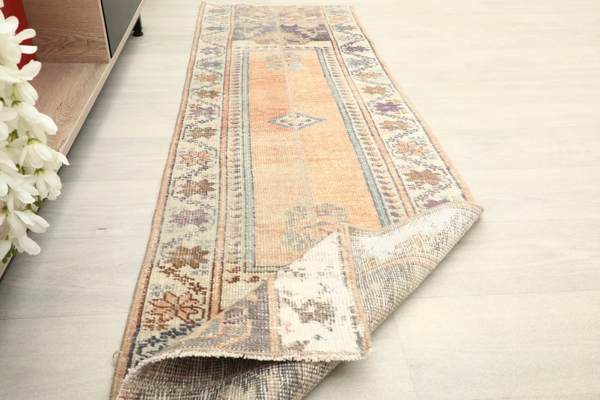 Angled view of the rug with one end folded back, showing the texture and construction.