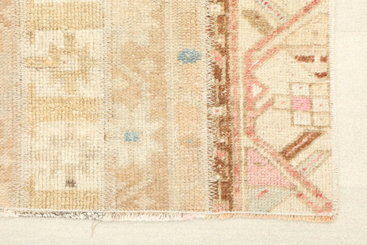Close-up of the rug's edge, showing the hand-knotted wool pile and fringe detail.
