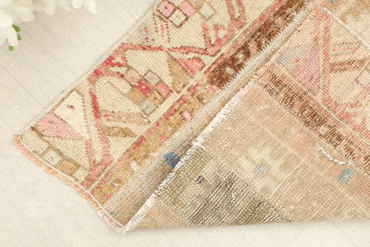 Folded corner of the rug, showing the thickness of the wool pile and cotton foundation.
